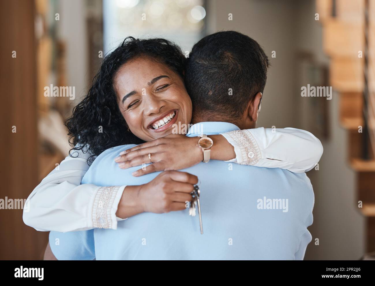 Hausschlüssel, neues Zuhause oder glückliches Paar, das sich für Immobilien, Immobilieninvestitionen oder den Erfolg einer Wohnung umarmt. Traum, Liebe oder Indianer, die sich freuen Stockfoto