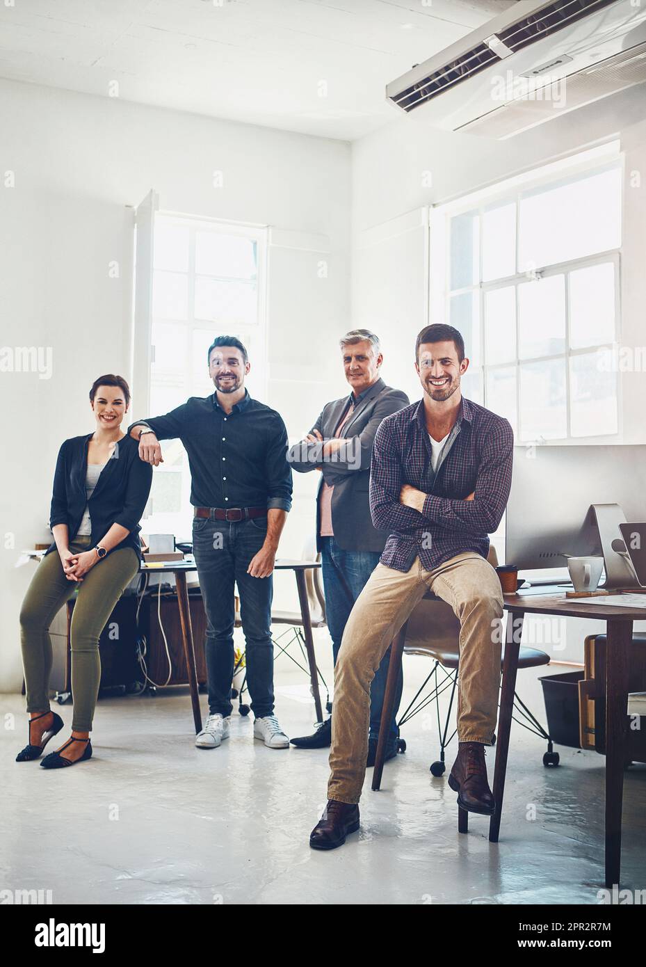 Gewöhnliche Menschen, die sich entschieden haben, außergewöhnliche Dinge zu tun. Porträt eines Teams kreativer Arbeiter, die in einem Büro zusammenstehen. Stockfoto