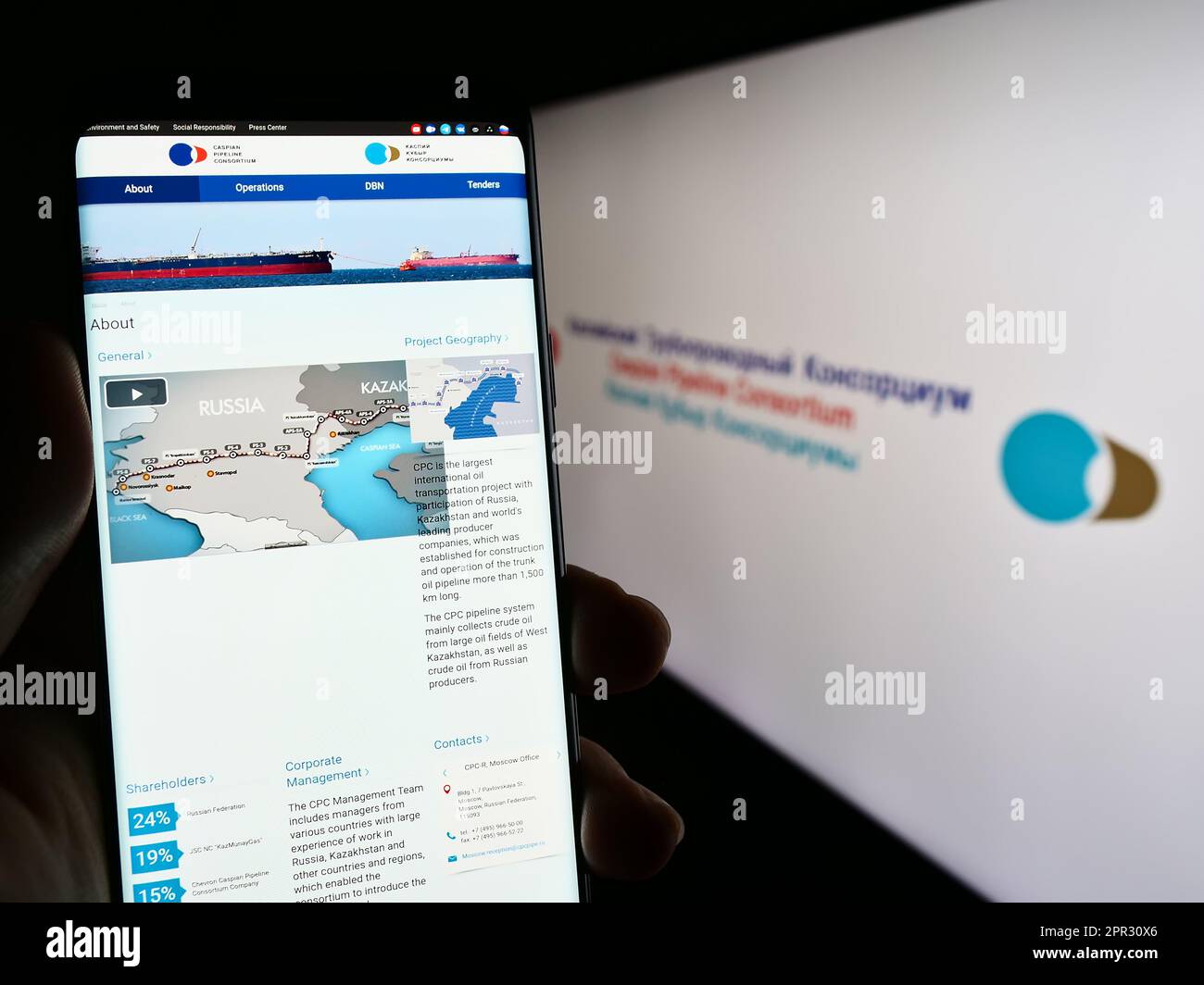 Person mit Smartphone und Website des Kaspischen Pipeline Consortiums (CPC) auf dem Bildschirm vor dem Logo. Konzentrieren Sie sich auf die Mitte des Telefondisplays. Stockfoto