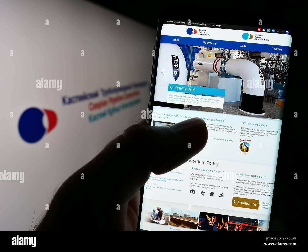 Person, die ein Mobiltelefon mit einer Webseite des Kaspischen Pipeline-Konsortiums (CPC) auf dem Bildschirm vor dem Logo hält. Konzentrieren Sie sich auf die Mitte des Telefondisplays. Stockfoto