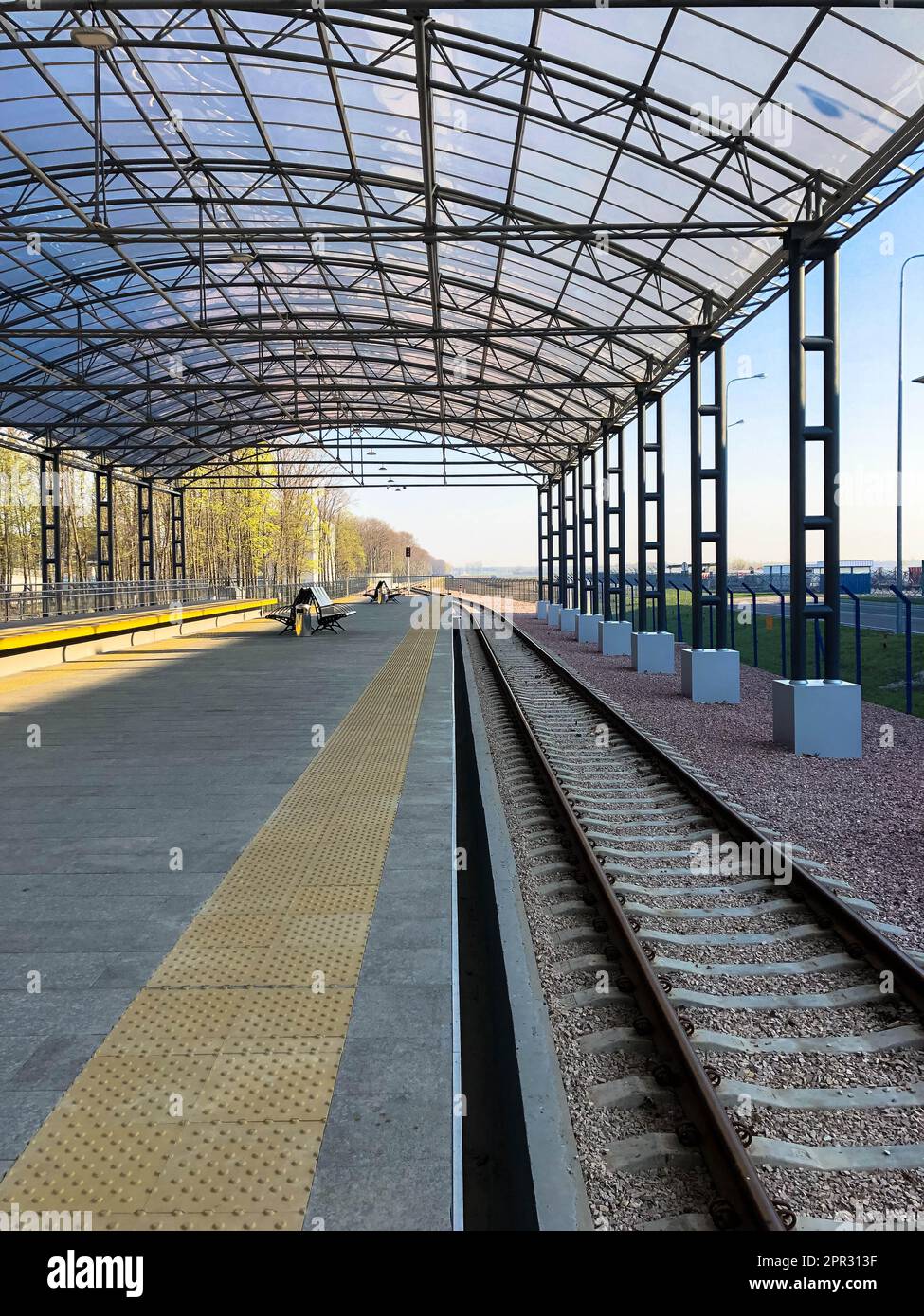 Moderner Bahnhof, Bahnhof mit transparentem Überdachung für Fahrgäste und Schienen. Stockfoto