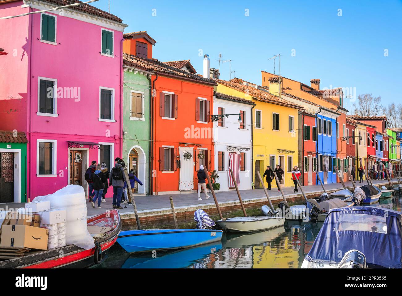 Farbenfrohe Häuser und Geschäfte am Kanal in der Sonne auf Burano Island, Venedig, Italien Stockfoto