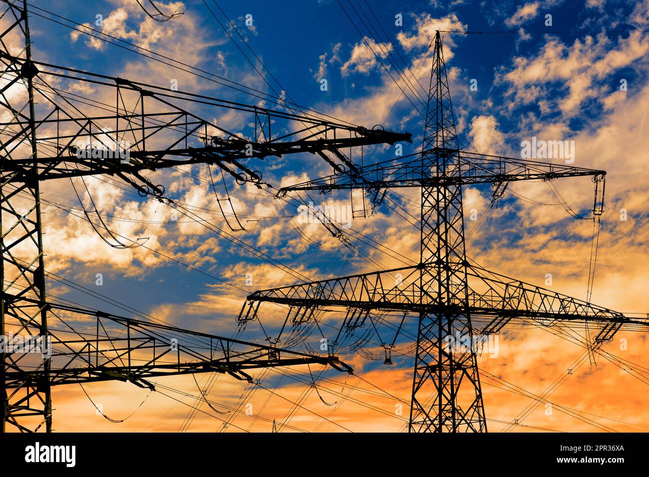 Elektrische Hochspannungsmasten gegen den Himmel mit dramatischen Wolken Stockfoto