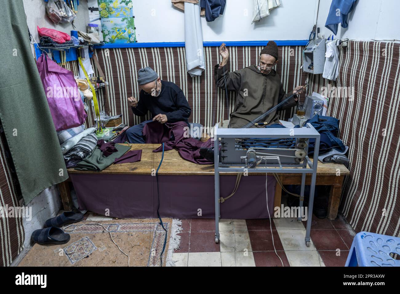 Männer nähen Djellabas von Hand in einer kleinen Werkstatt in der Kasbah von Tanger. Stockfoto