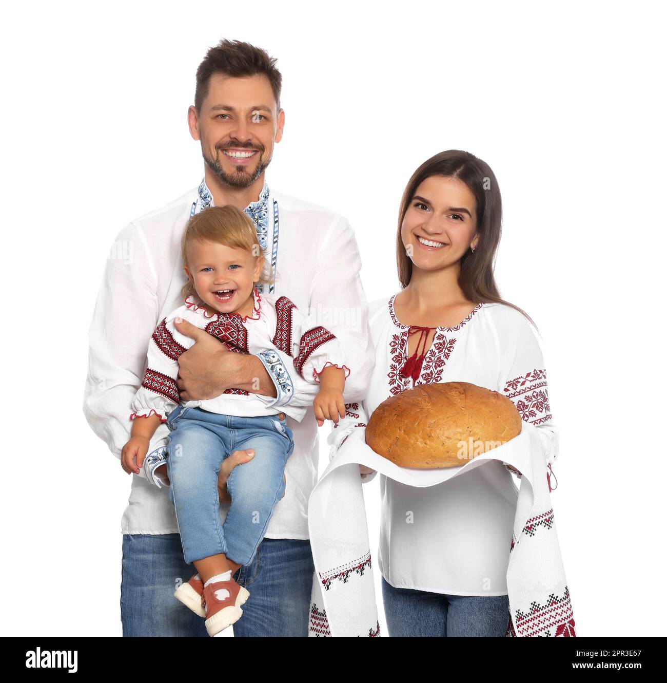 Glückliche ukrainische Familie in bestickten Hemden mit Korovai-Brot auf weißem Hintergrund Stockfoto