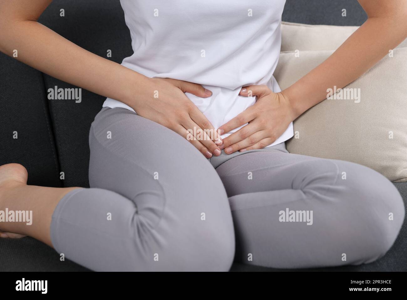 Frau mit Zystitis auf dem Sofa zu Hause, Nahaufnahme Stockfoto