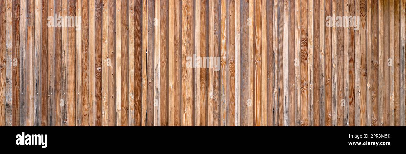 Panorama-Holzwand aus vertikalen Brettern in verschiedenen Brauntönen Stockfoto