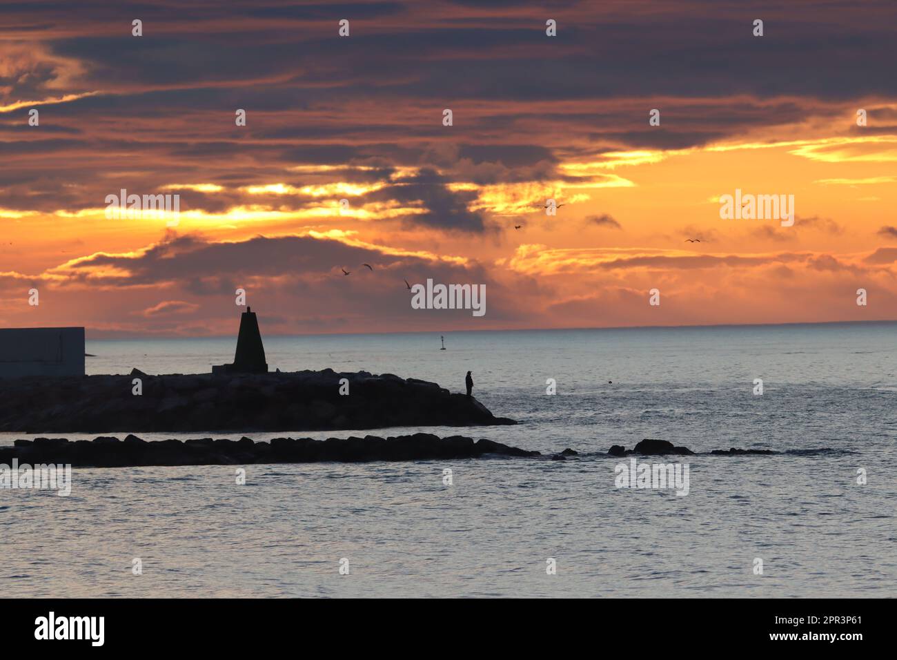 Gelber Sonnenaufgang mit Fischern und Sonnenaufgang hinter den Wolken Stockfoto