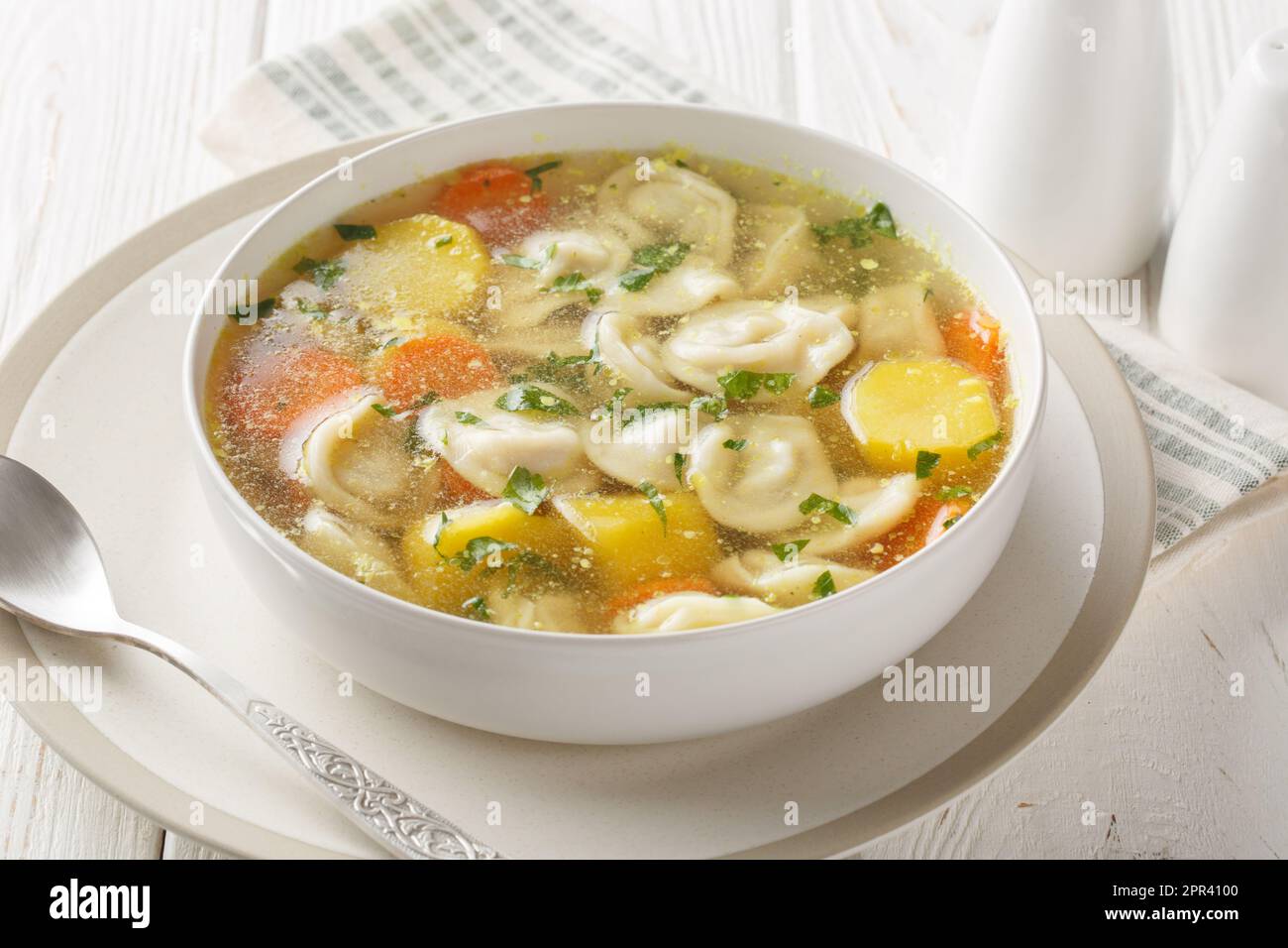 Suppe mit Pelmeni-Teigtaschen ein Gericht der russischen Küche, das auf der Schüssel auf dem Holztisch auftaucht. Horizontal Stockfoto