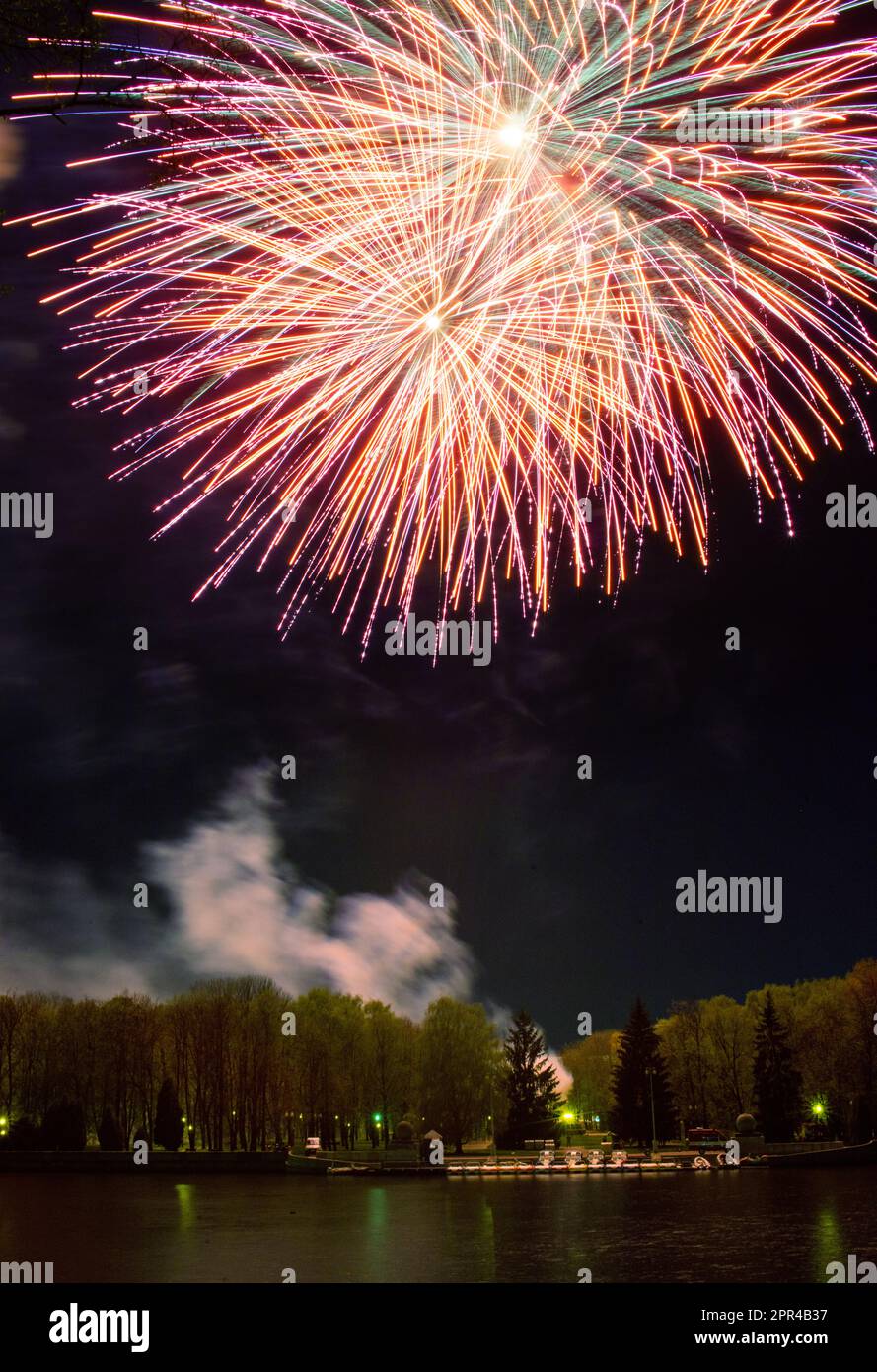 Helle mehrfarbige Feuerwerkslichter am schwarzen Nachthimmel während der Feiertage Stockfoto