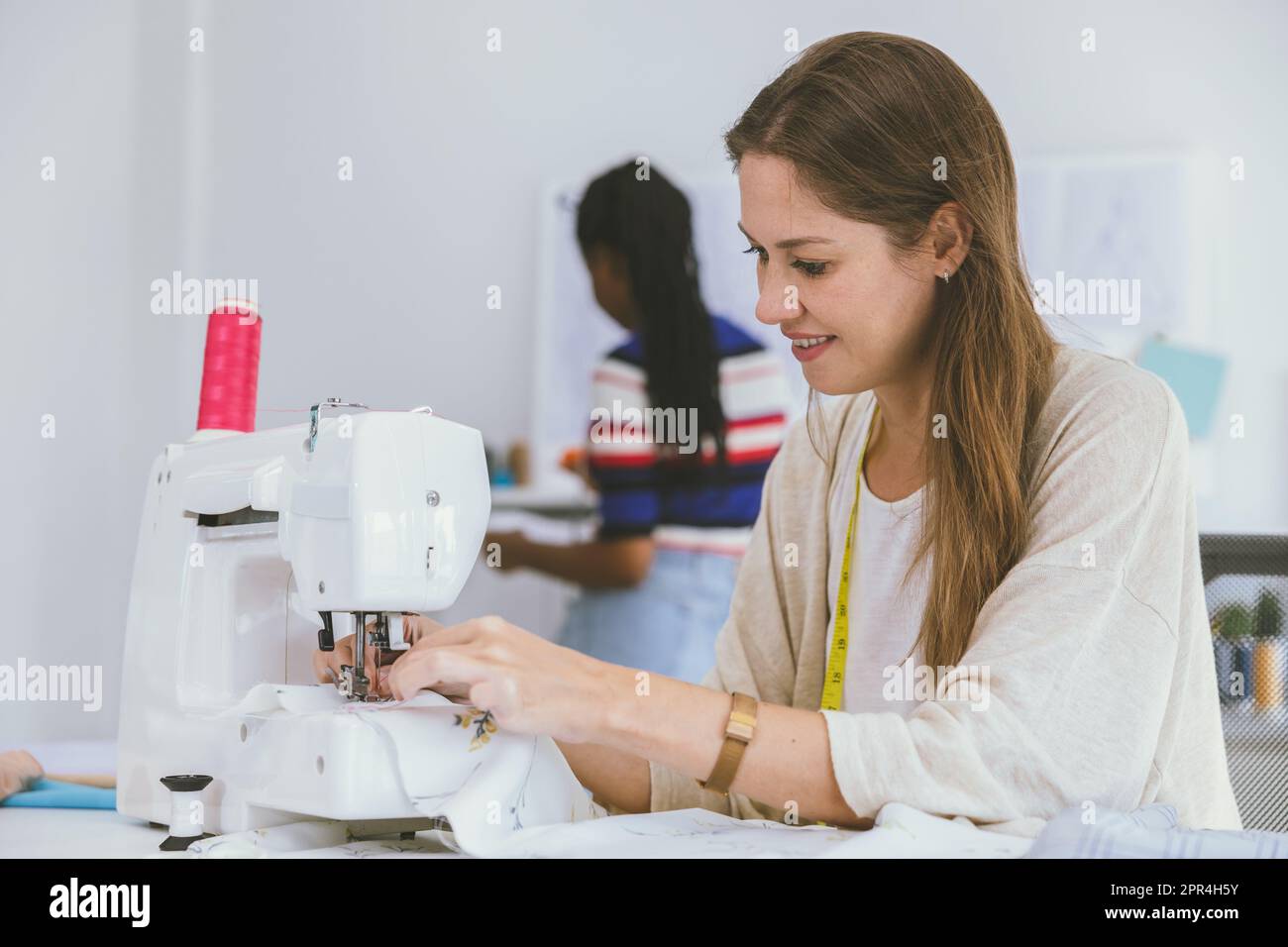 Happy Schneider Woman Fashion Stylish Bekleidungsdesignerin arbeitet mit Nähmaschine im eigenen Business Studio Stockfoto
