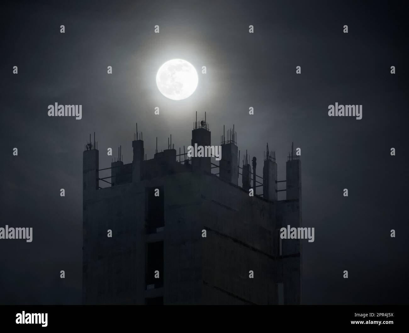 Vollmond über einer Baustelle, der Beton und der Geist eines Liftschachts, der gebaut wird, bei Nacht im Mondlicht, Entwicklung in Manchester Stockfoto