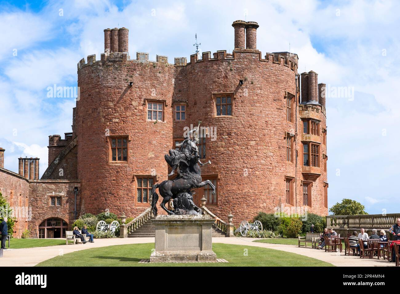 Menschen im äußeren Innenhof von Powis Castle, einer mittelalterlichen Festung, mit der Fame-Statue, Keep- und Trommeltürmen an der Westfront, Powys, Wales Stockfoto