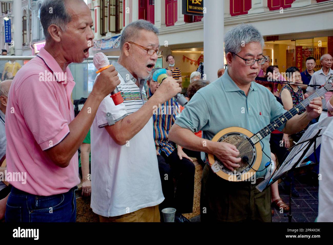 Drei Singapur-Rentner, ein chinesischer Lautenspieler und zwei chinesische Sänger spielen traditionelle chinesische Lieder: Chinatown, Singapur Stockfoto