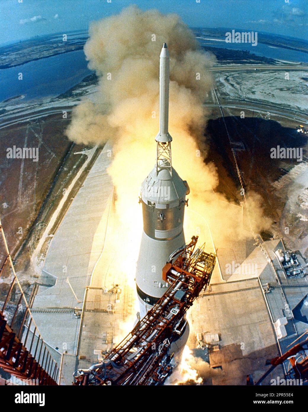 Um 9:32 Uhr EDT ziehen sich die Schwingenarme weg und eine Flamme signalisiert den Start des Raumfahrzeugs Apollo 11 Saturn V und der Astronauten Neil A. Armstrong, Michael Collins und Edwin E. Aldrin, Jr. vom Kennedy Space Center Launch Complex 39A. Stockfoto