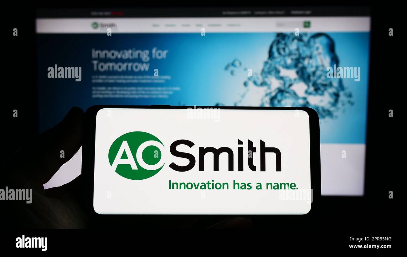Person, die ein Smartphone mit dem Logo der US-amerikanischen Firma A. O. Smith Corporation auf dem Bildschirm vor der Website hält. Konzentrieren Sie sich auf das Display des Telefons. Stockfoto