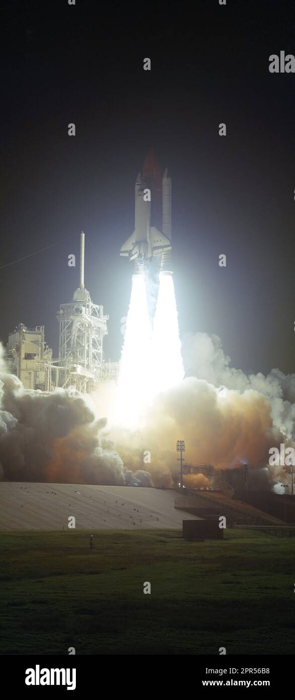 STS-35 Columbia, Orbiter Vehicle (OV) 102, auf seinem externen Tank (ET) und flankiert von zwei soliden Raketenverstärkern (SRBs), verlässt den Startturm während seines Abflugs vom Kennedy Space Center (KSC) Launch Complex (LC) Pad 39B um 1:49 Uhr (Eastern Standard Time (EST)). OV-102 steigt über die mobile Abschussrampe, die von einer Auspuffwolke bedeckt ist, die vom Glühen des SRB und des Space Shuttle-Haupttriebwerks (SSME) beleuchtet wird. Stockfoto