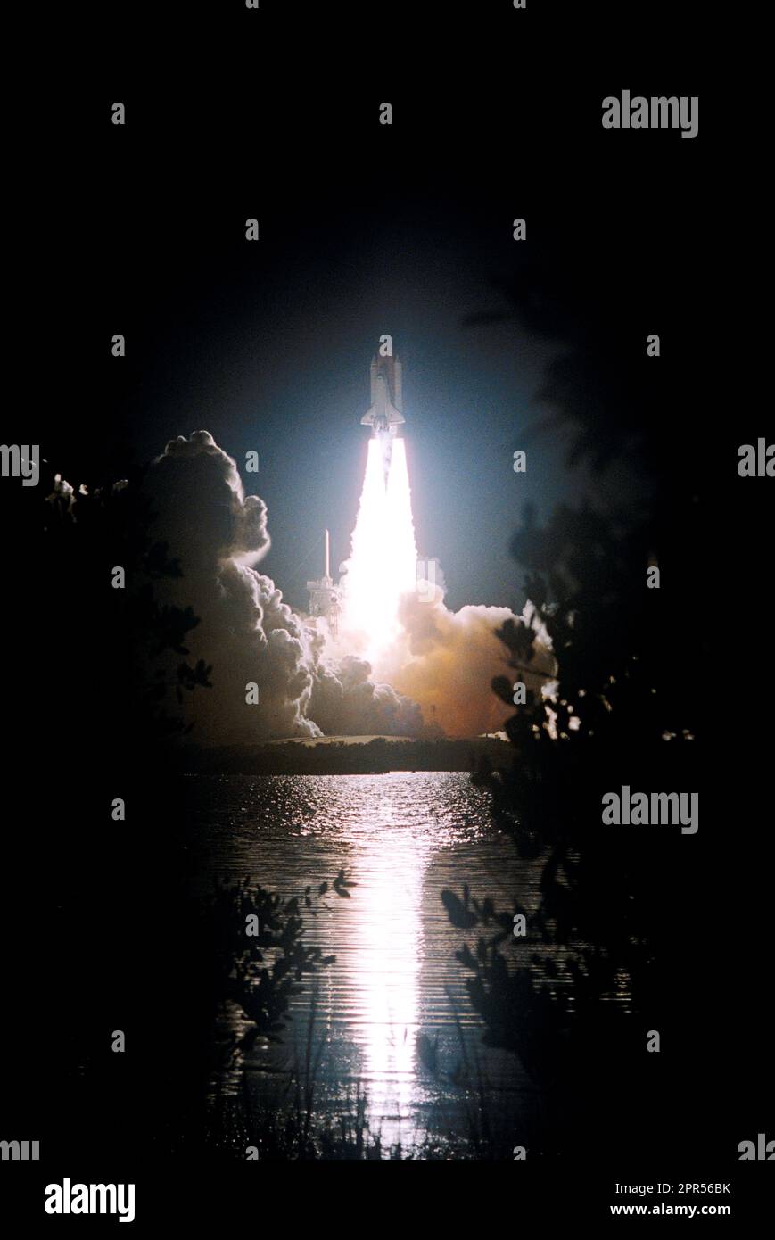 Der feurige Start der Space Shuttle Discovery von Launch Pad 39B auf Mission STS-116 spiegelt sich im nahegelegenen Wasser wider. Der Start erfolgte pünktlich um 8:47 Uhr Östliche Normalzeit. Das war die 33. Mission der Discovery, der erste Nachtstart seit 2002, und die 20. Shuttle-Mission zur Internationalen Raumstation. Stockfoto