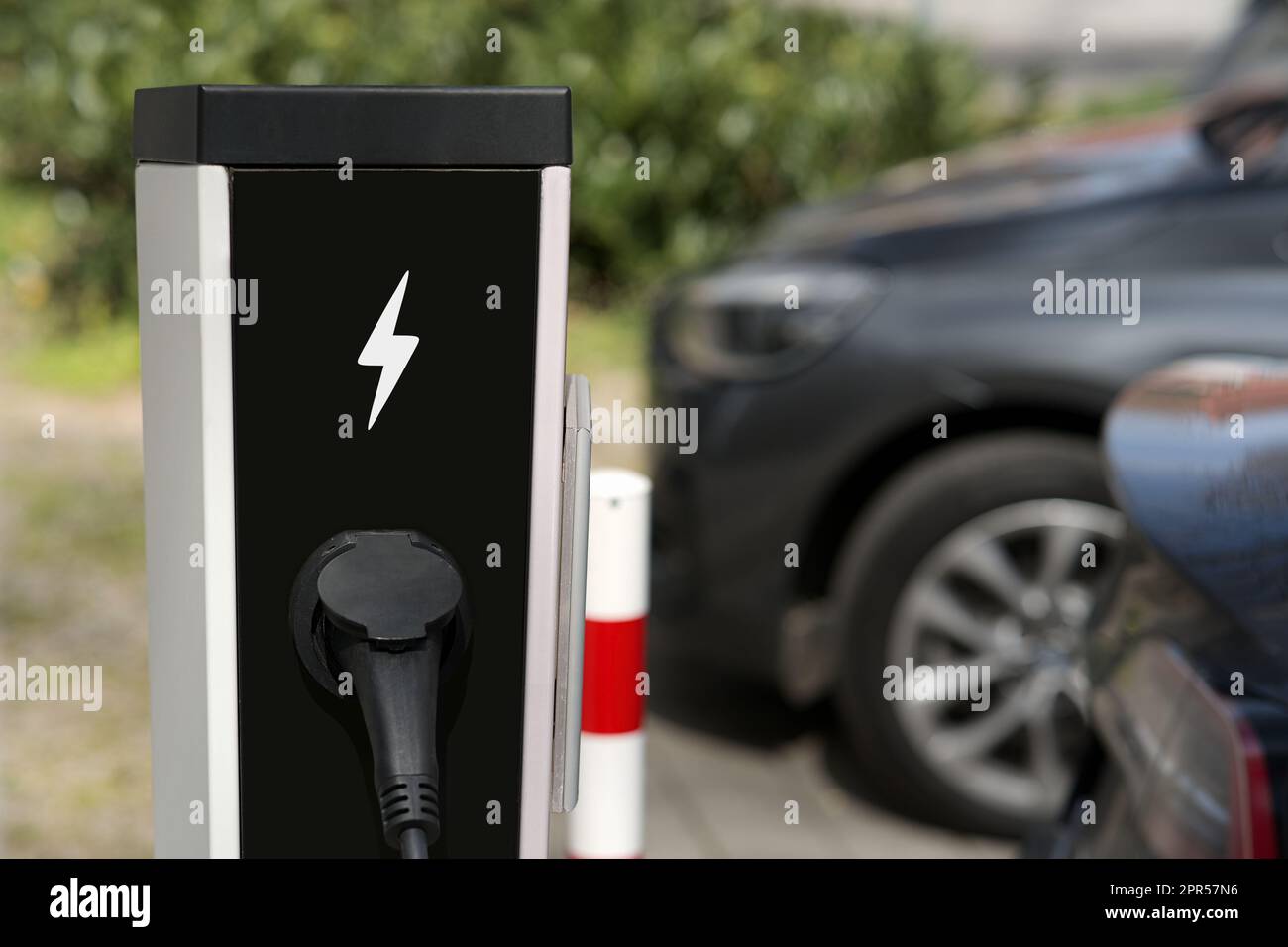 Elektrische Aufladung von Elektroautos an einer öffentlichen, im Freien installierten Ladestation für Kraftfahrzeuge auf dem Parkplatz Stockfoto