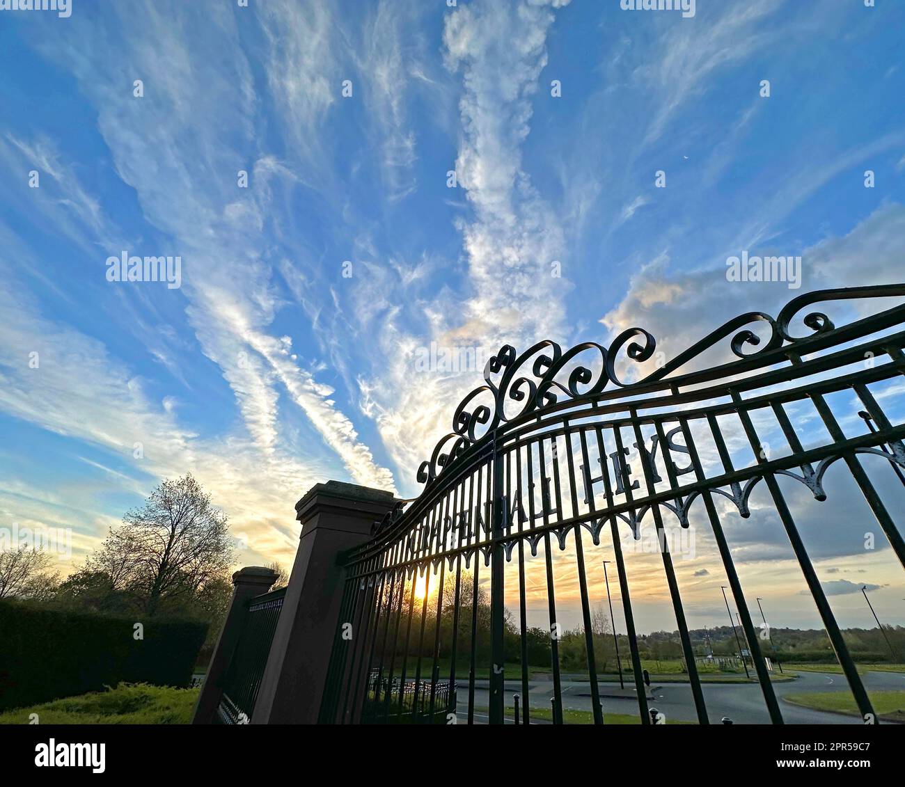 Sonnenuntergang hinter den Toren bei Grappenhall Heys Immobilienentwicklung, Witherwin Avenue, South Warrington, Cheshire, England, UK, WA4 3DS Stockfoto