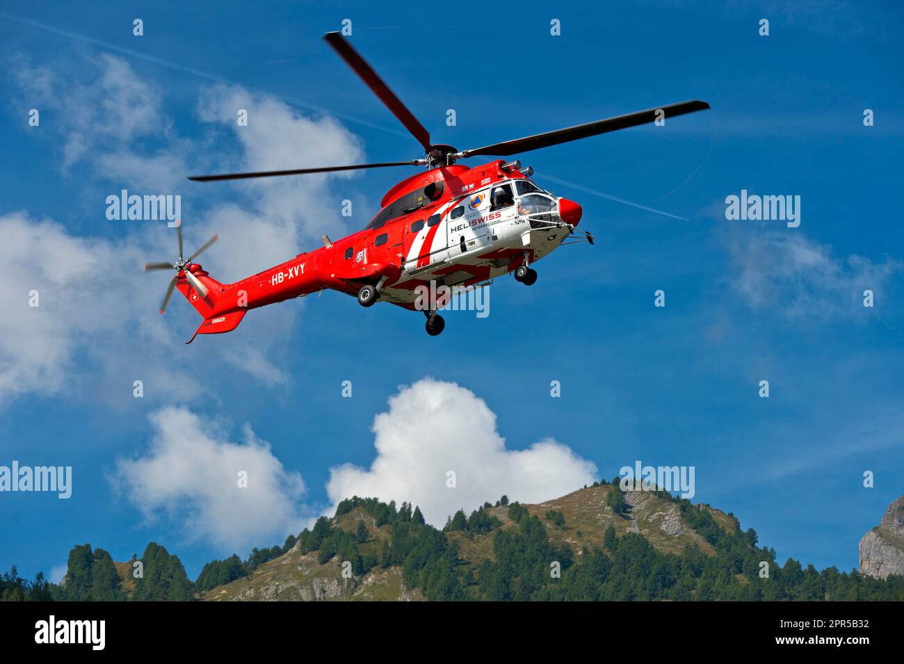 Multifunktionaler Transporthubschrauber AS 332 Super Puma C1 HB-XVY von Heliswiss International AG auf einem Flug in den Pennine Alps, Valais, Schweiz Stockfoto