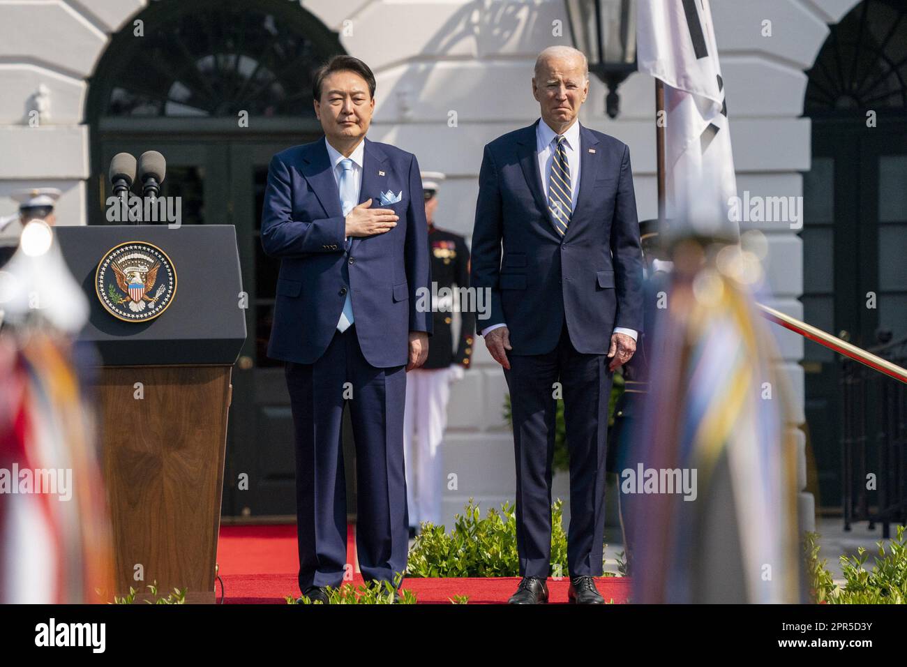 Washington, Usa. 26. April 2023. Präsident Joe Biden und der südkoreanische Präsident Yoon Suk Yeol (L) hören bei einer Ankunftszeremonie auf dem South Lawn während eines Staatsbesuchs im Weißen Haus in Washington, DC am Mittwoch, den 26. April 2023. Yoon ist am zweiten Tag eines dreitägigen Besuchs in DC. Foto: Ken Cedeno/UPI Credit: UPI/Alamy Live News Stockfoto
