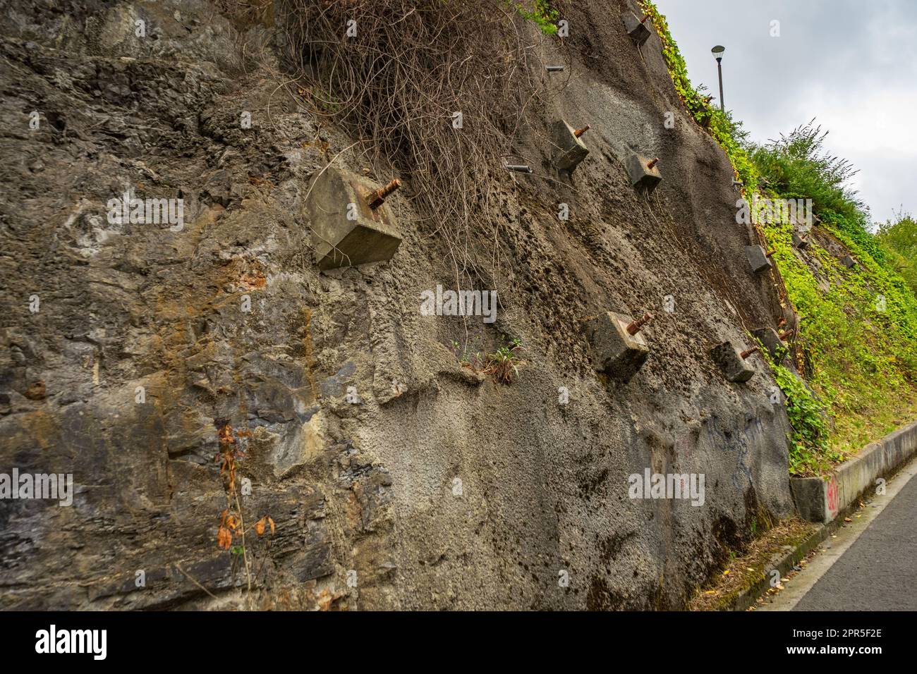 Felsanker und Anker zum Schutz der Hänge vor Zerstörung. Schutz des felsigen Gefälles vor dem Einsturz durch verstärkte Betonanker Stockfoto