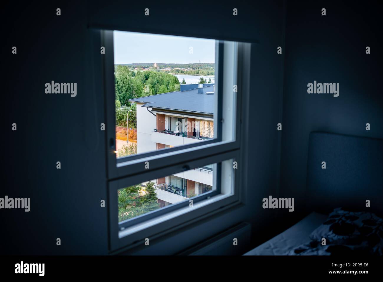 Fenster in der Wohnung. Wohnungsbauhaus draußen, Nachbar. Dunkles Zimmer. Mietwohnungen oder Immobilien. Straße im Wohngebiet. Stockfoto