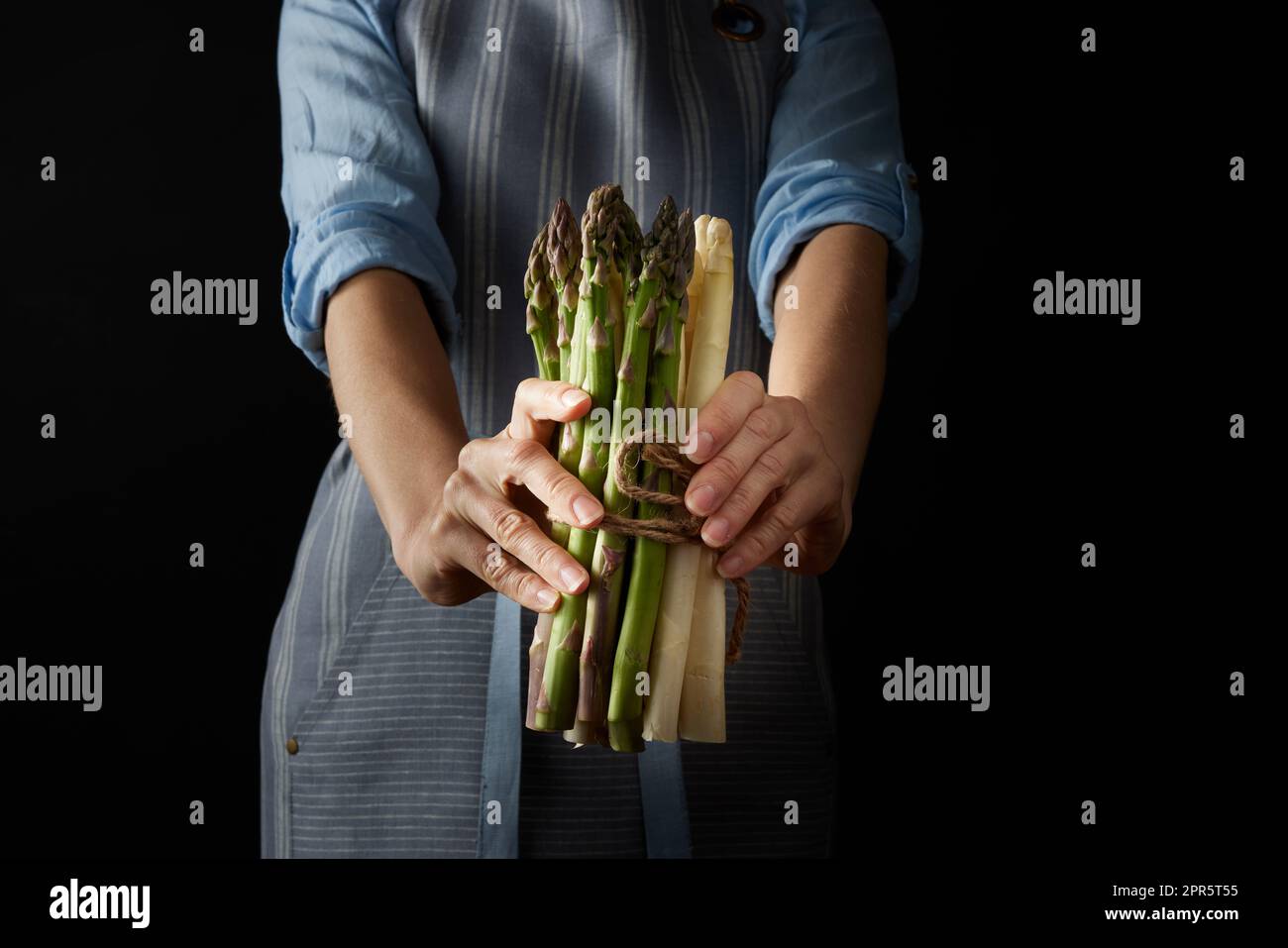 Gesichtsloser Koch mit rohem Spargel Stockfoto