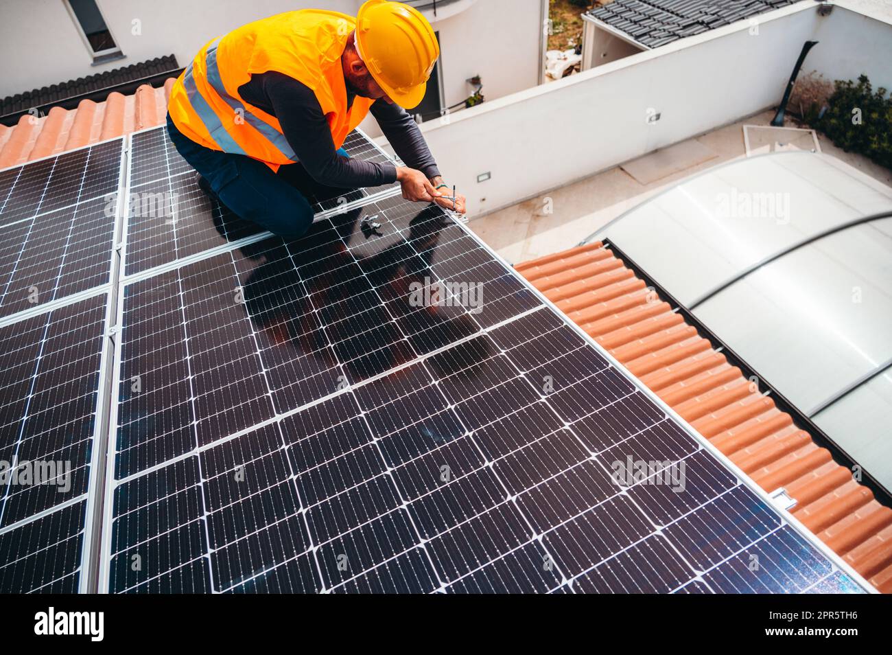 Arbeiter bauen Energiesystem mit Solarpanel für Strom Stockfoto