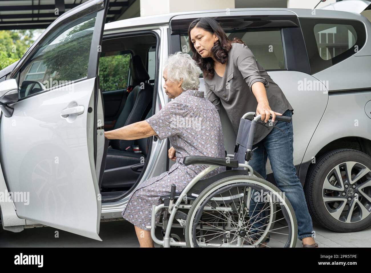 Hilfe und Unterstützung asiatische ältere oder ältere alte Dame Frau Patientin bereiten zu ihrem Auto zu bekommen. Stockfoto