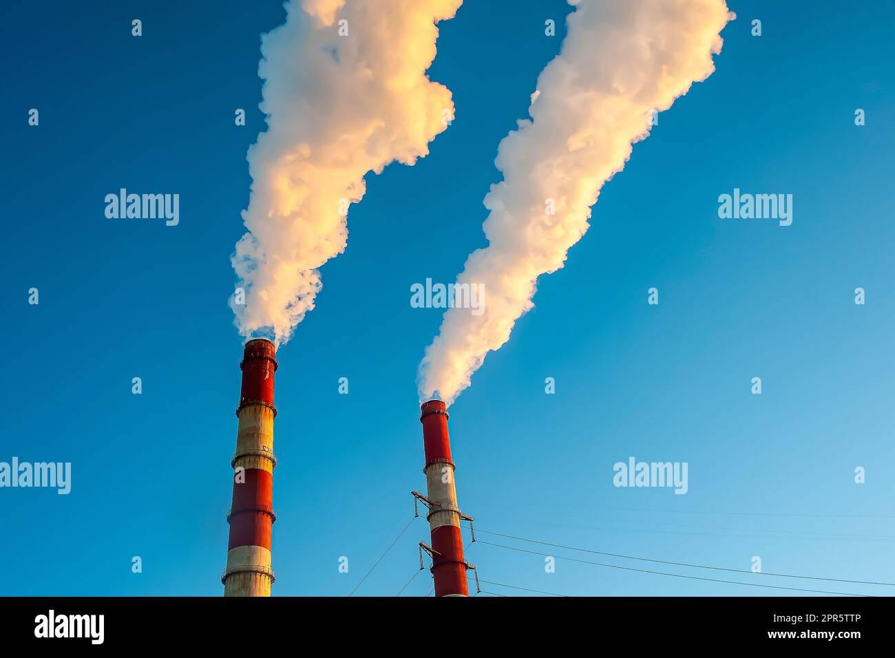 Weißer Rauch kommt aus den Rohren am blauen Himmel Stockfoto