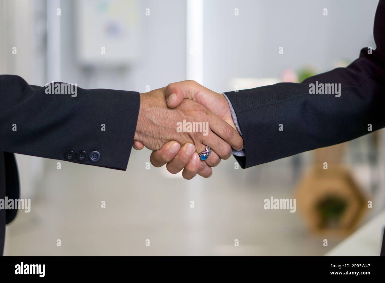 Geschäftspartner geben sich im modernen Büro die Hände. Nahaufnahme Stockfoto