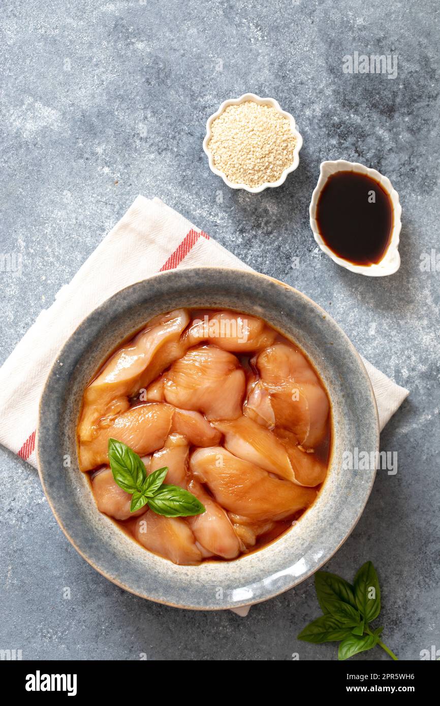 Rohkost mariniertes Hühnerfleisch mit Teriyaki-Sauce in einer grauen Schüssel. Marinieren von Fleisch zum Kochen Grill Stockfoto