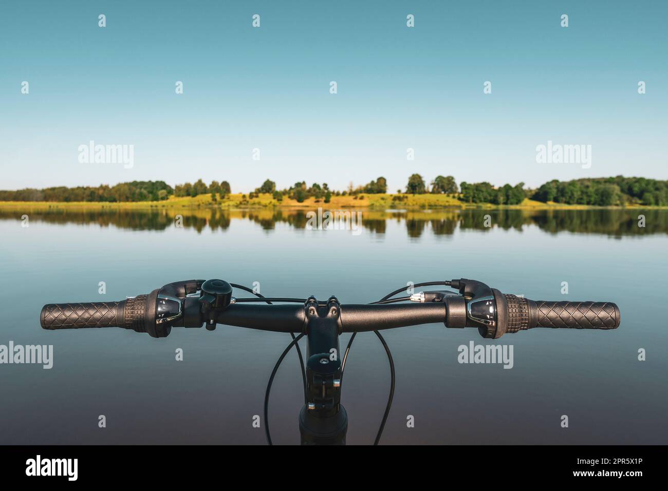 Fahrradlenker im ruhigen Hintergrund des Sees Stockfoto