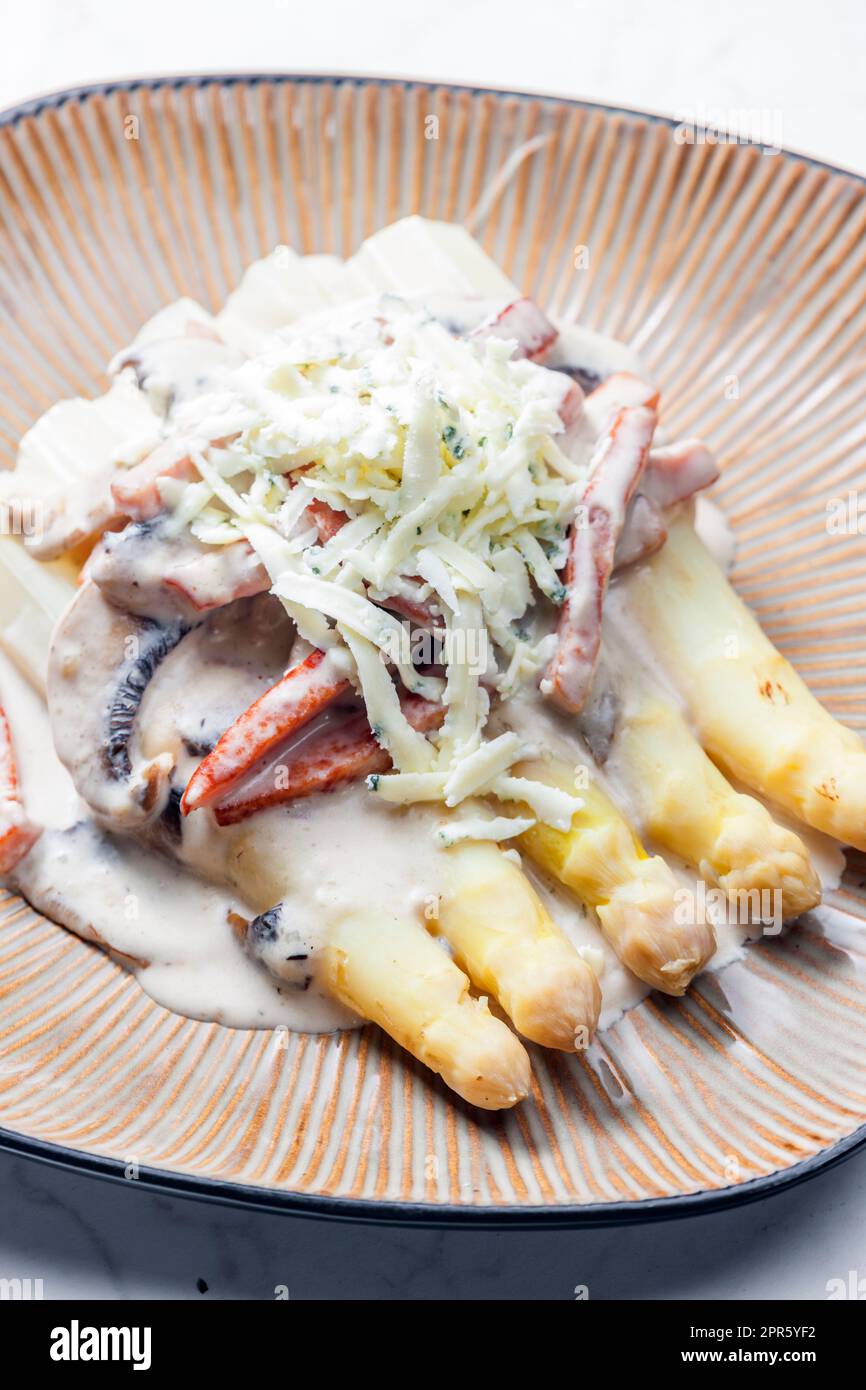 Weißer Aparagus mit Pilzsauce und Schinken, serviert mit Blauschimmelkäse Stockfoto