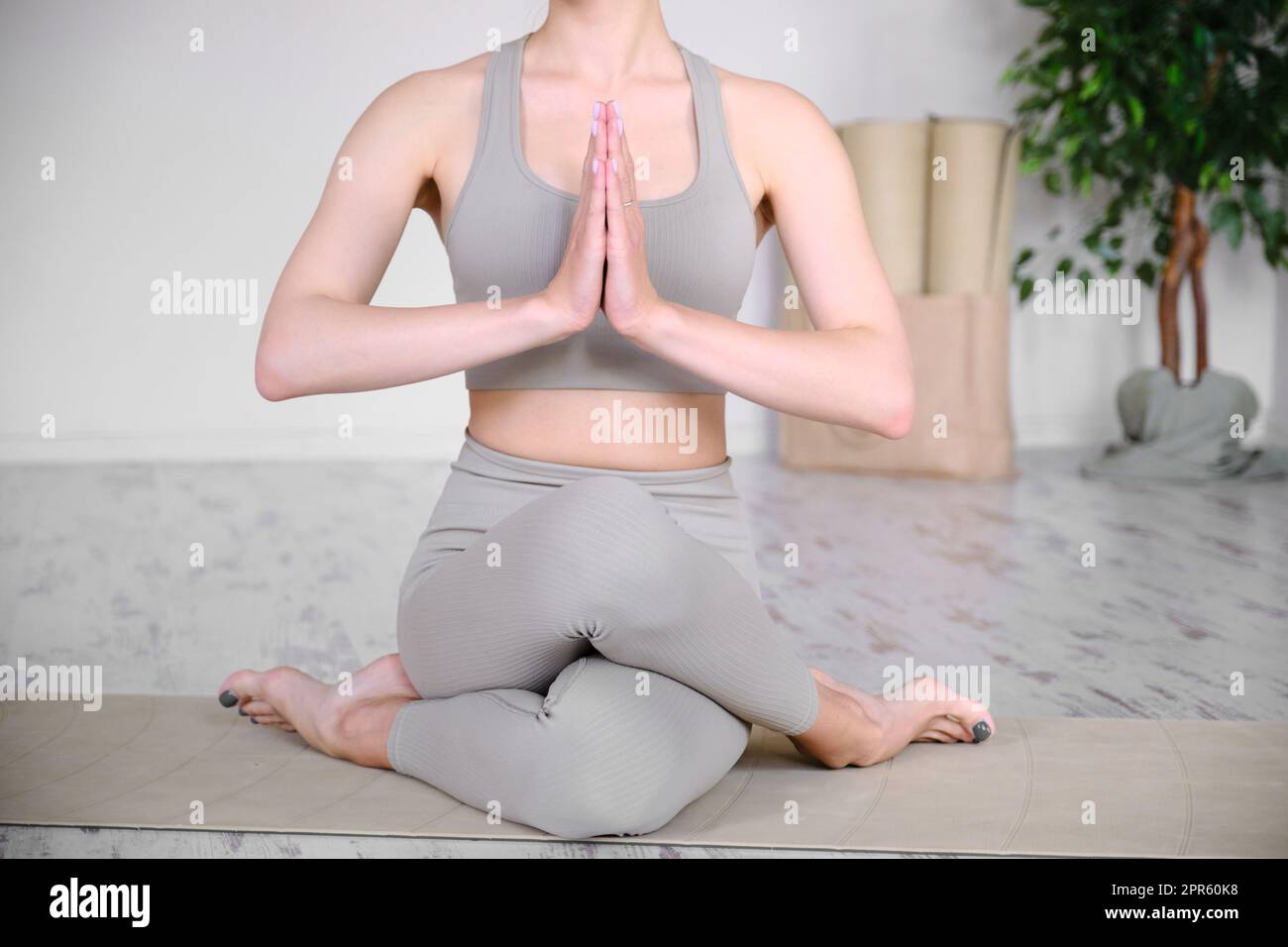 Schöner, athletischer weiblicher Körper in einer Halb-Lotusposition. Yoga, Meditation und Ruhe üben. Stockfoto