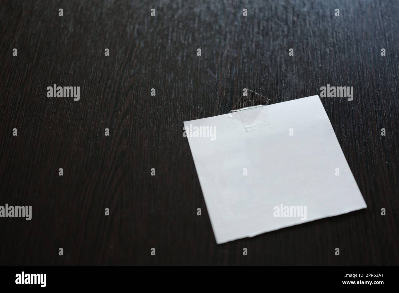 Weißes Papierkissen auf schwarzem Holztisch. Platz für Text Stockfoto