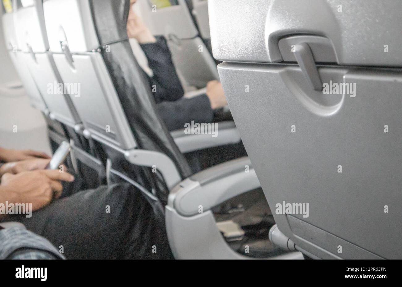 Selektiver Fokus auf einem geschlossenen Tisch, einem Tisch für Speisen in der Kabine, einem verschwommenen Hintergrund der Passagiere im Innenraum, dem Konzept bequemer Flüge und Reisen Stockfoto