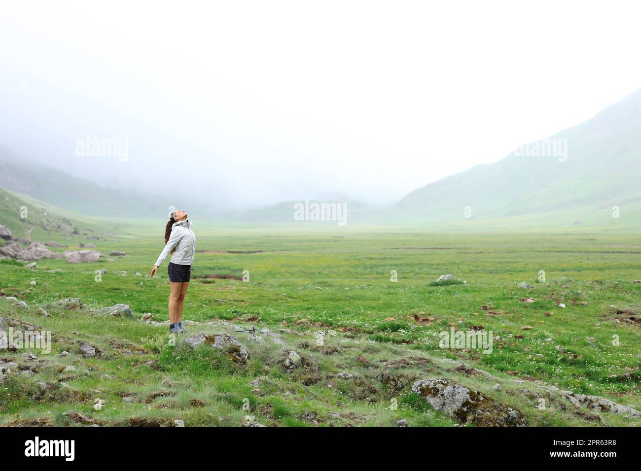 Trekker atmet frische Luft im Berg an einem nebligen Tag Stockfoto