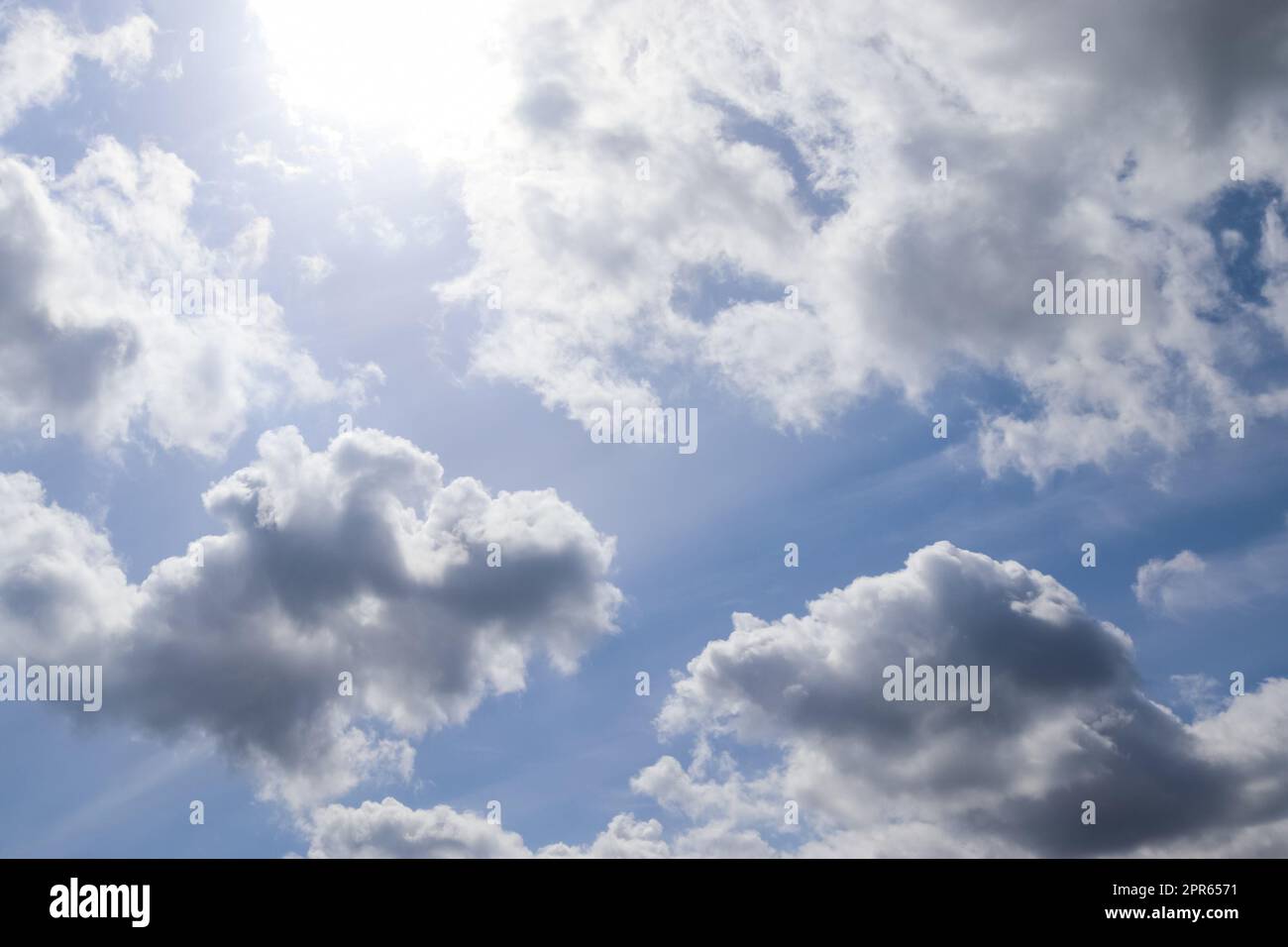 Wunderschöner Blick auf die Sonnenstrahlen mit einigen Lichtreflexionen und Wolken in einem blauen Himmel Stockfoto