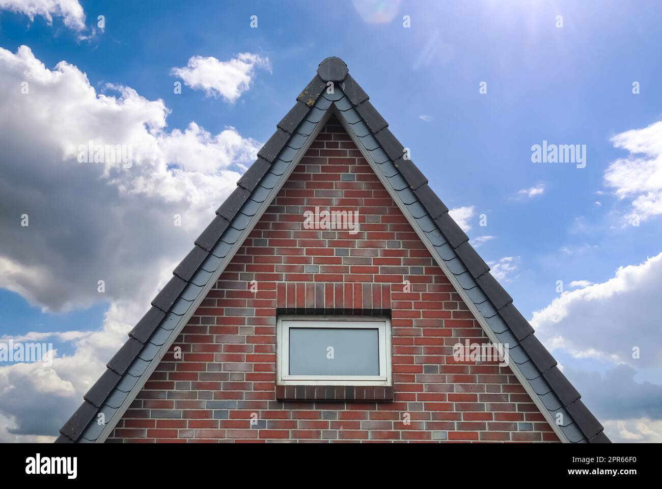 Dachfenster im Velux-Stil mit dunklen Dachziegeln. Stockfoto