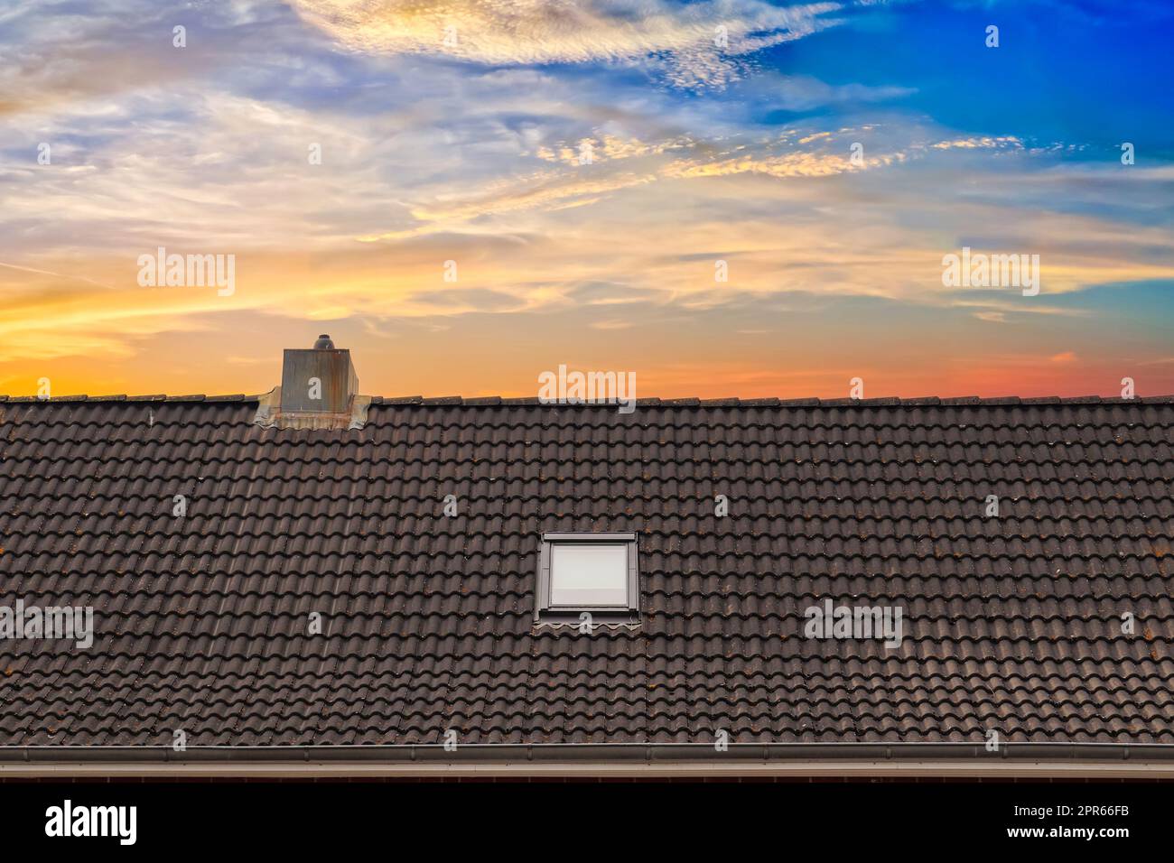Dachfenster im Velux-Stil mit dunklen Dachziegeln. Stockfoto
