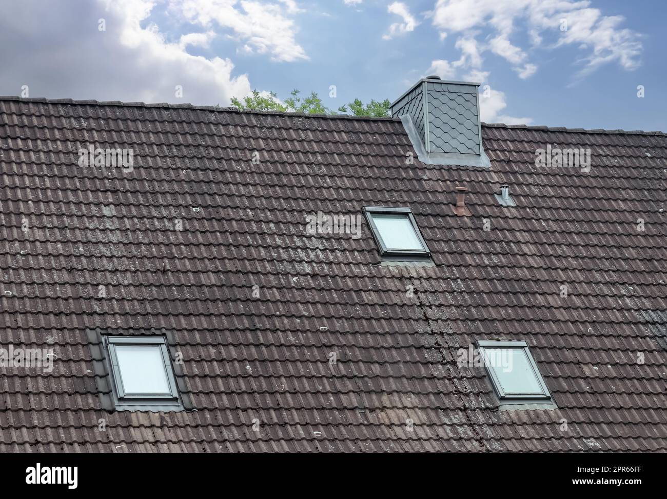 Dachfenster im Velux-Stil mit dunklen Dachziegeln. Stockfoto