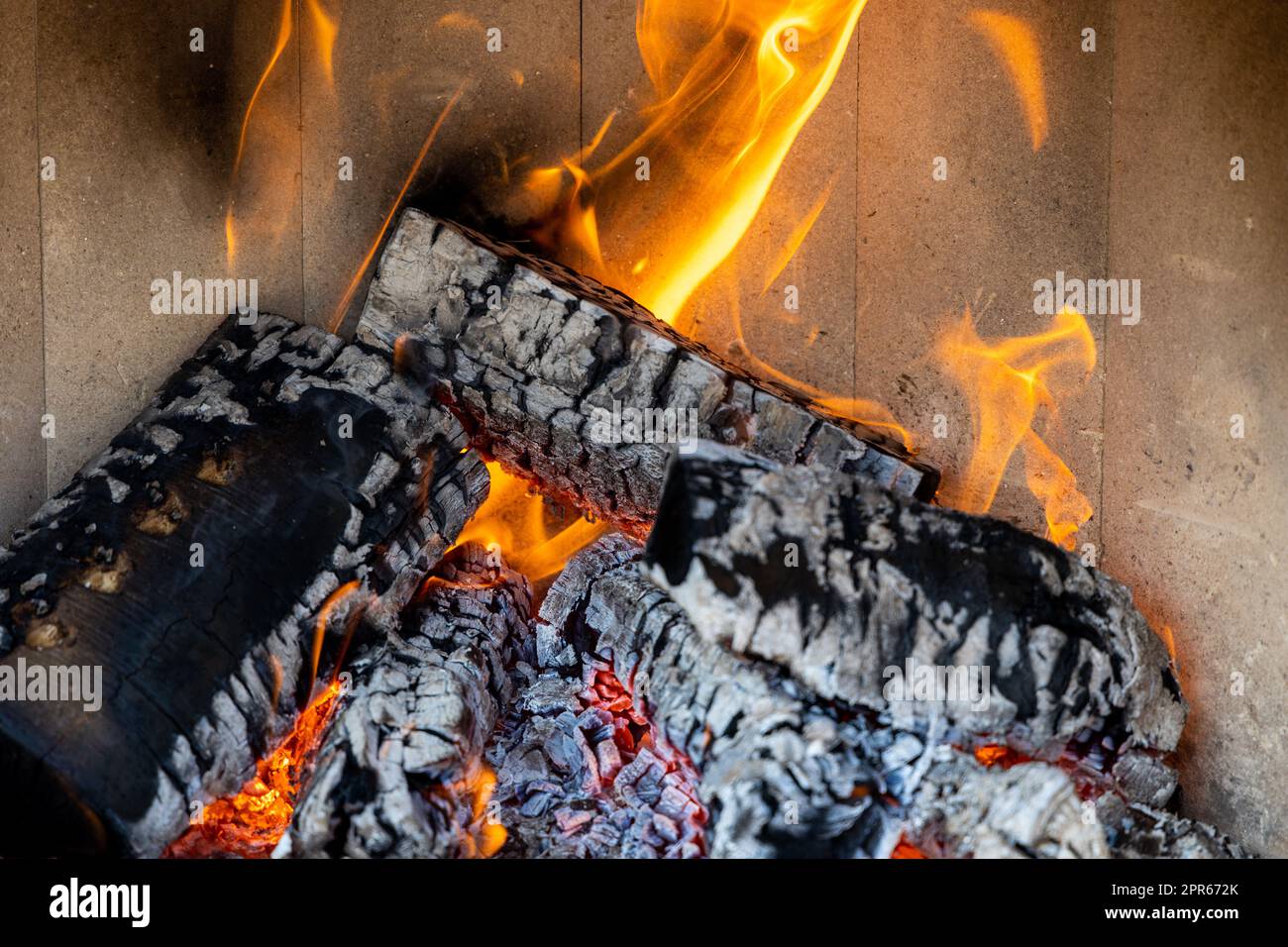 Brennendes Holz in einem Kamin mit viel Glut Stockfoto