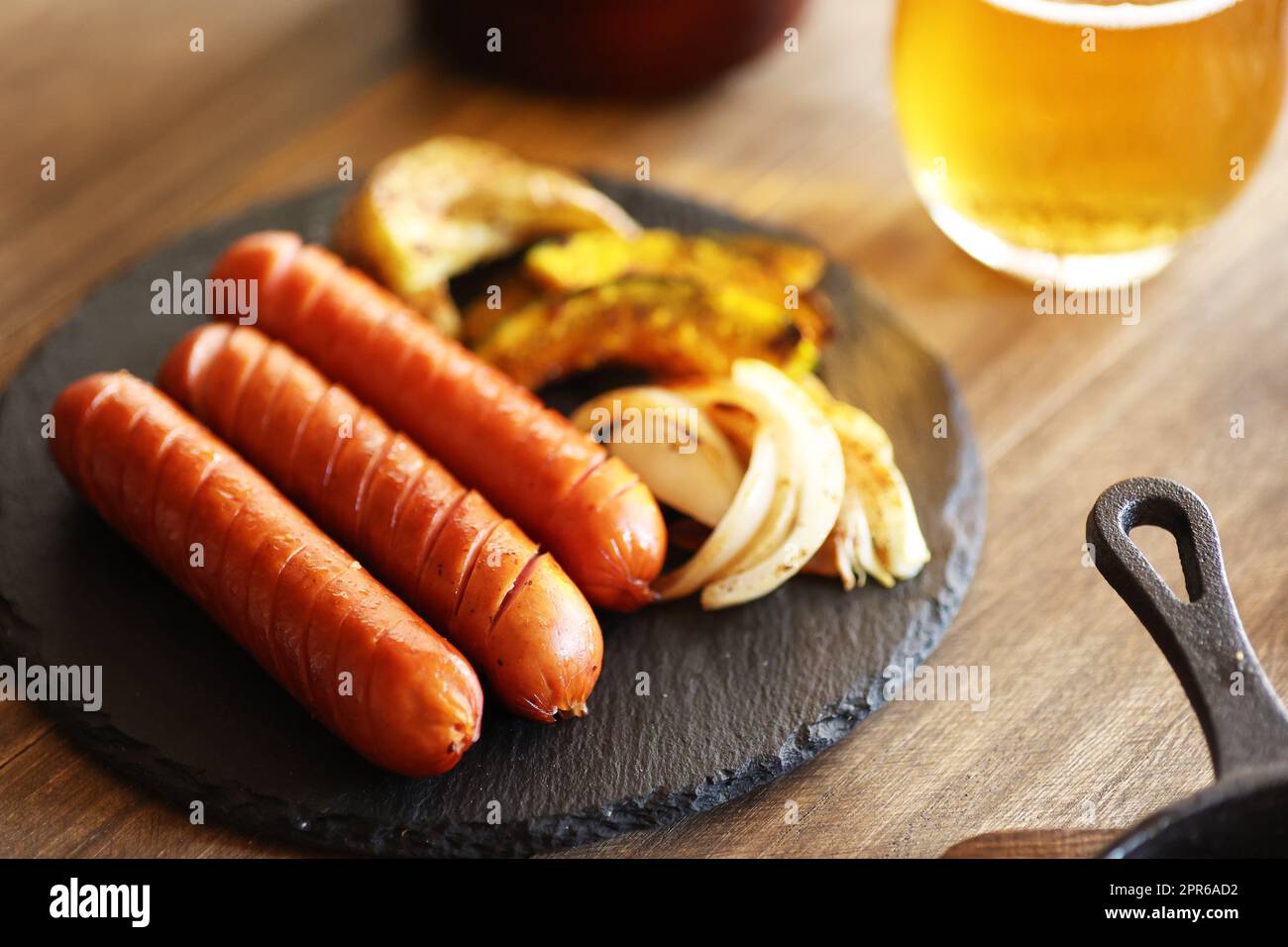 Würstchen und gegrilltes Gemüse mit einem Glas Bier Stockfoto