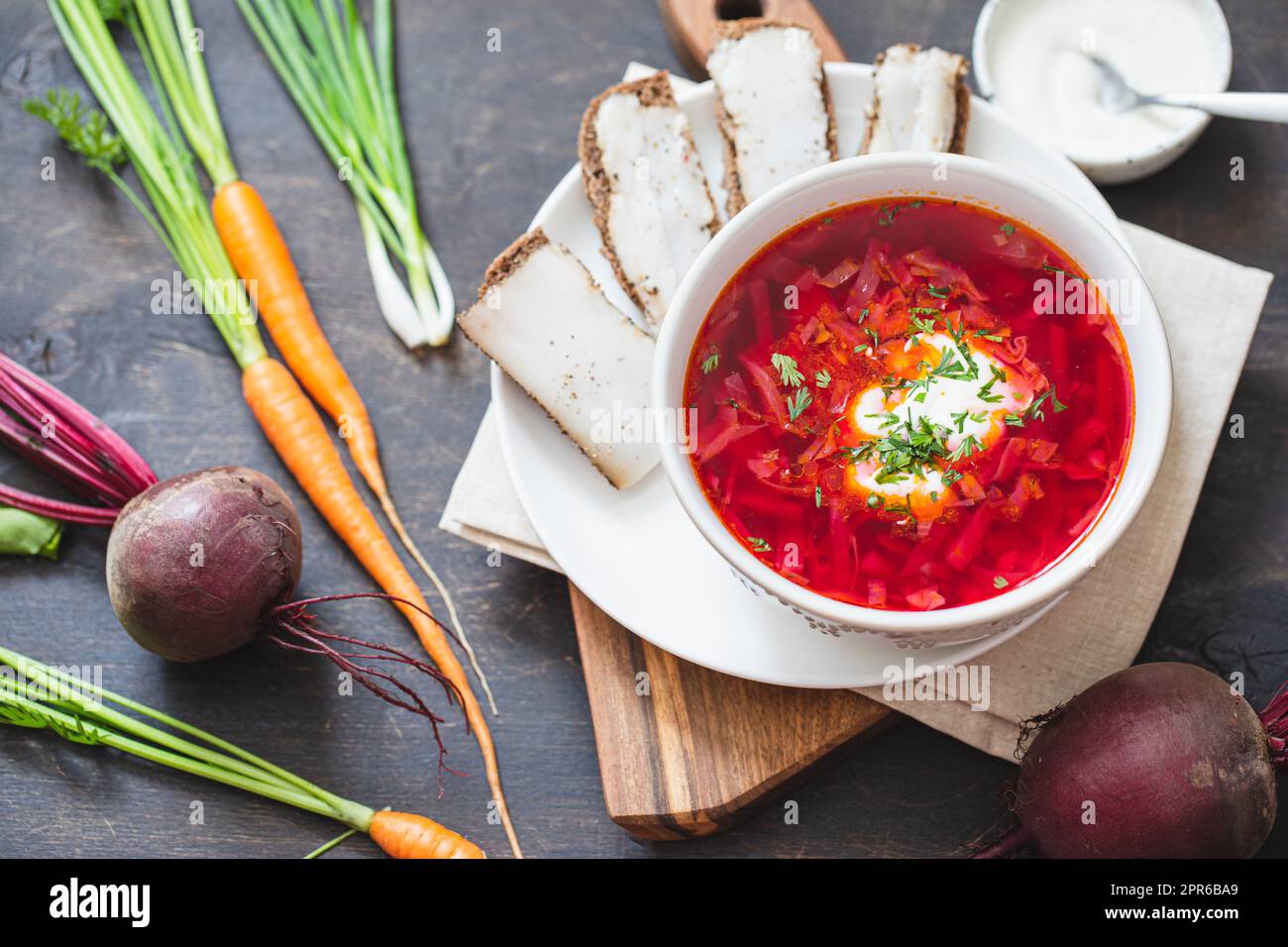 Ukrainisches rotes Nationalgericht Borsch, Rübensuppe, auf die UNESCO-Liste aufgenommen. Borscht mit Sauerrahm. Rote Bete Borscht mit Petersilie. Stockfoto