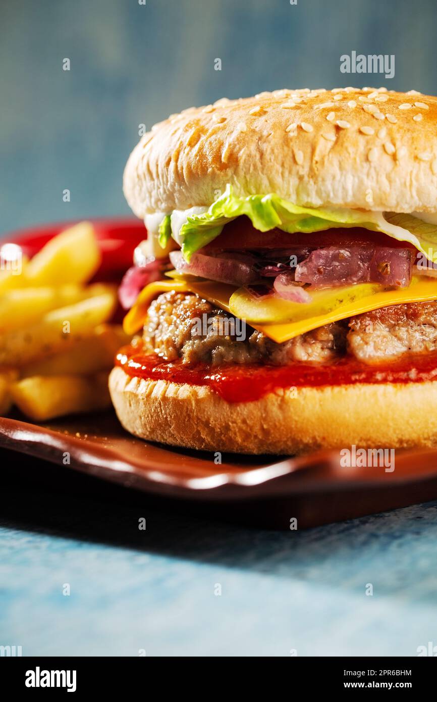 Burger. Saftiges Schweinekotelett, Cheddar-Käse, knusprig eingelegte ...