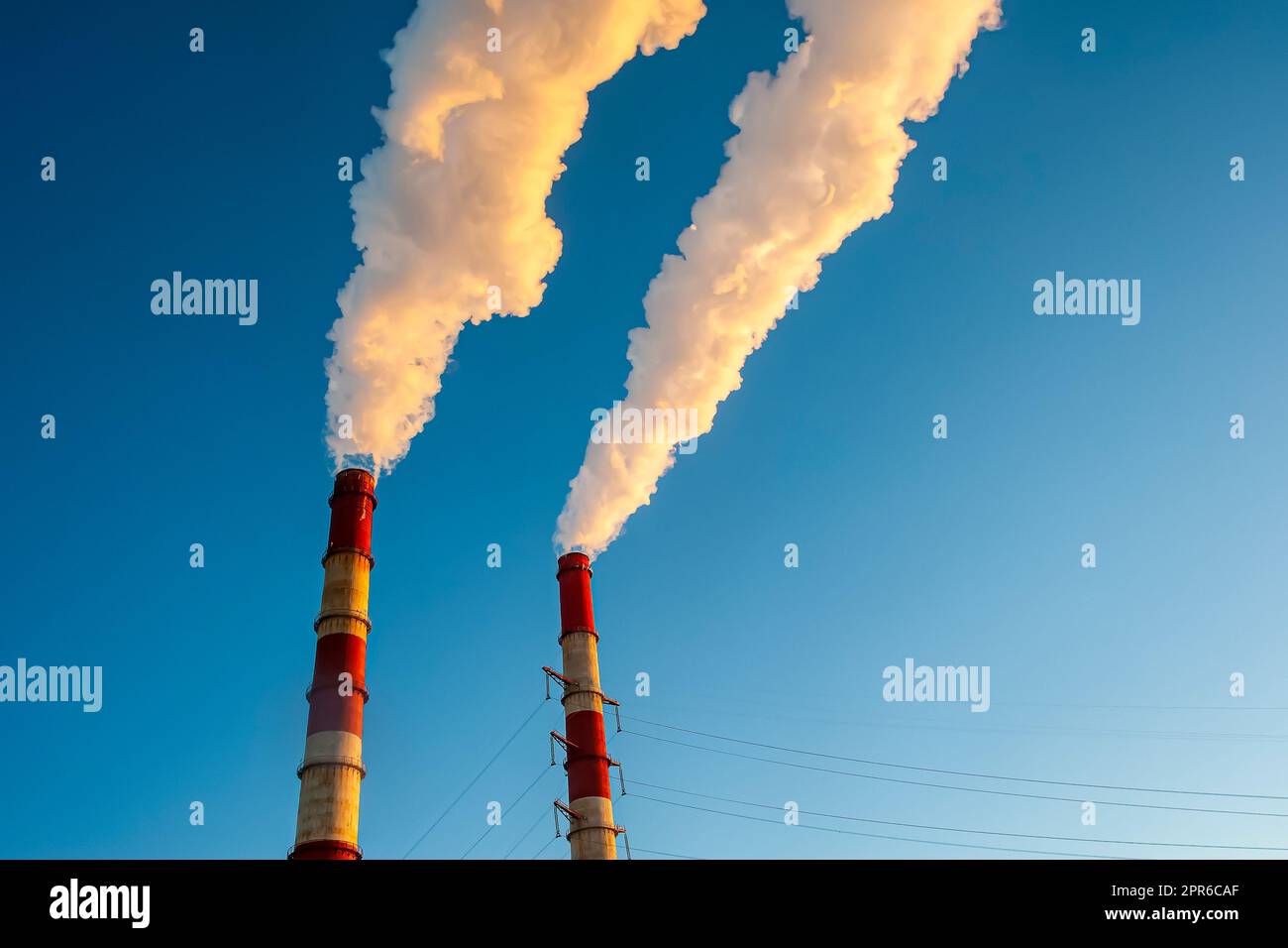 Weißer Rauch kommt aus den Rohren am blauen Himmel Stockfoto