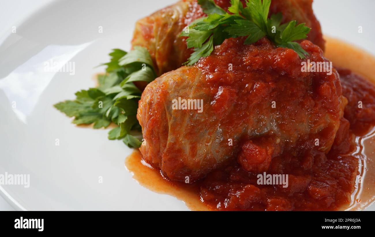 Gefüllte Kohlrollen mit Tomatensauce und Kräutern Stockfoto